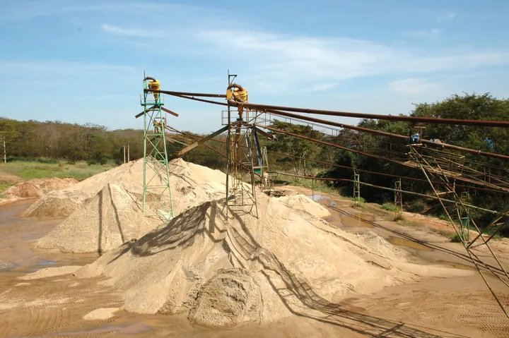 Pilhas de areia sob equipamentos de movimentação